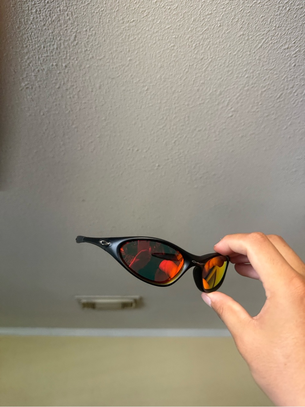 Oakley Black Frame Sunglasses with Red-Orange Mirrored Lenses